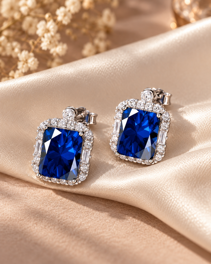 Blue rectangular halo earrings with sparkling clear stones on ivory satin