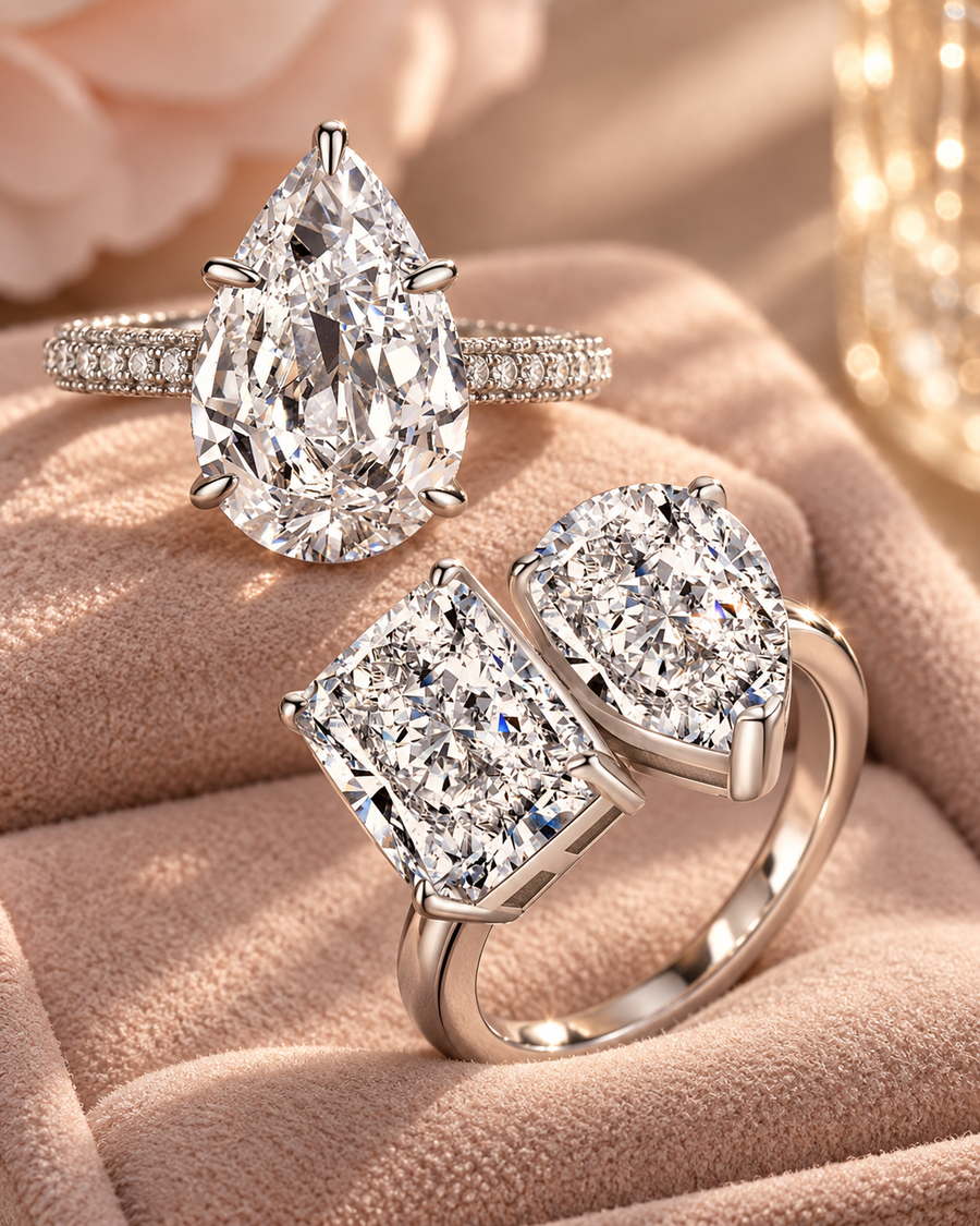 Statement two-stone and pear-cut silver rings on a warm nude display